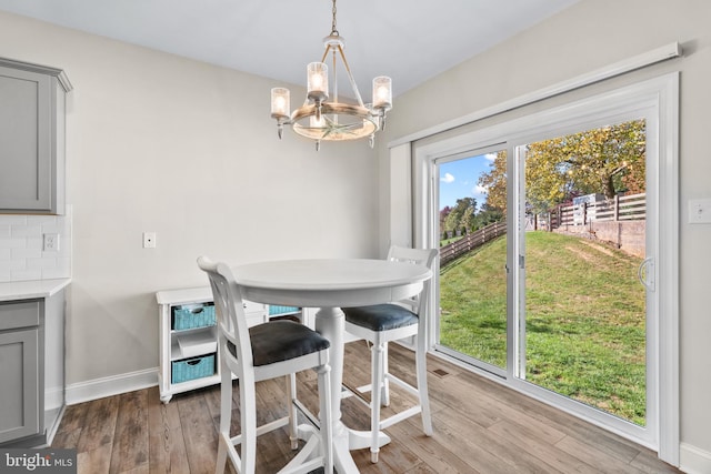 dining space with a notable chandelier and hardwood / wood-style floors