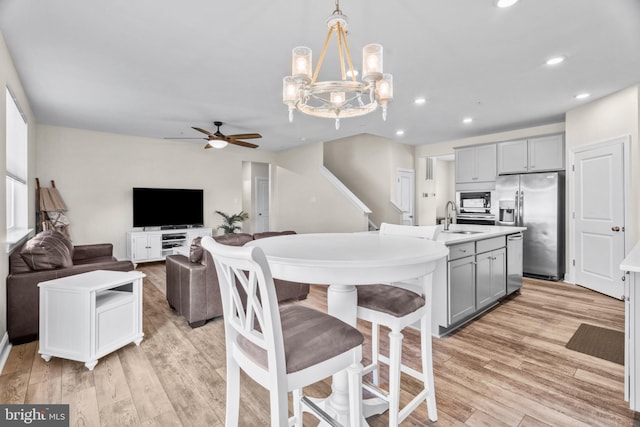 kitchen with black microwave, stainless steel fridge, gray cabinetry, and sink