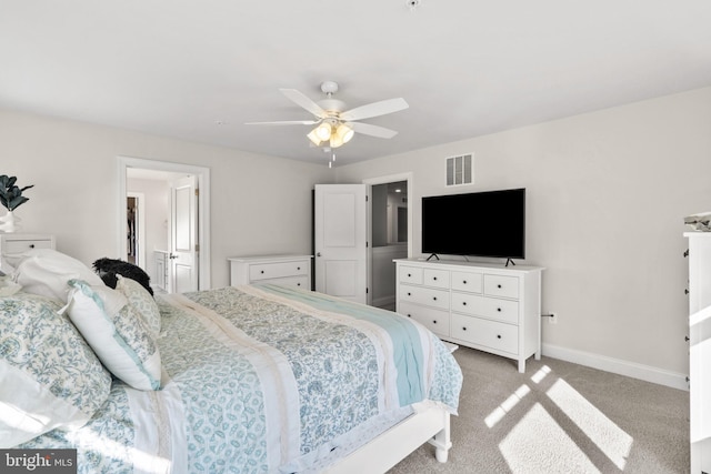 carpeted bedroom with ensuite bathroom and ceiling fan