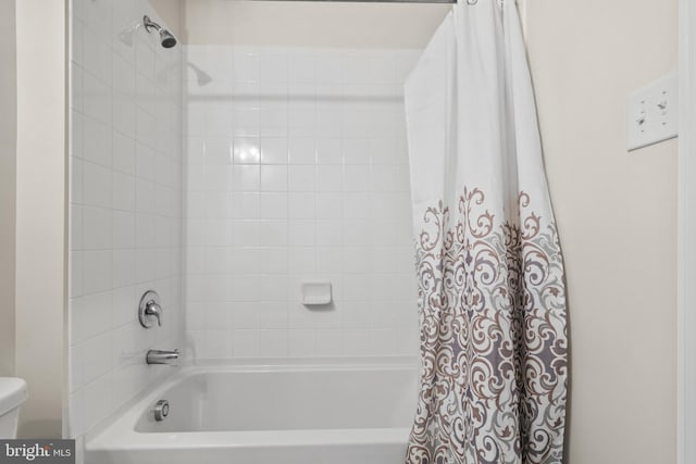 bathroom with shower / tub combo and toilet