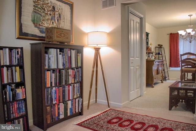 sitting room with a chandelier and carpet flooring