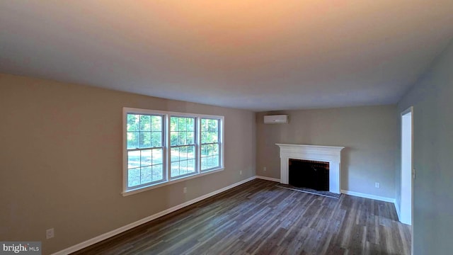 unfurnished living room with dark wood-type flooring and a wall unit AC