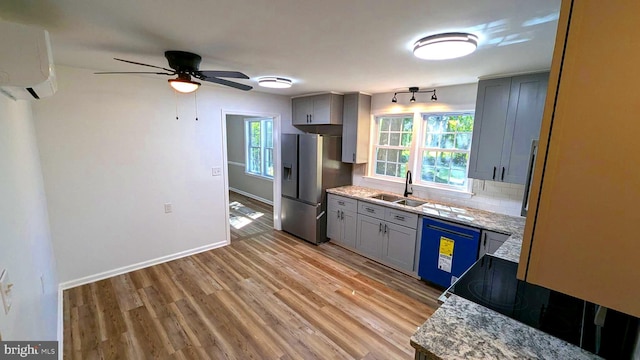 kitchen with light stone counters, black dishwasher, sink, and stainless steel fridge with ice dispenser