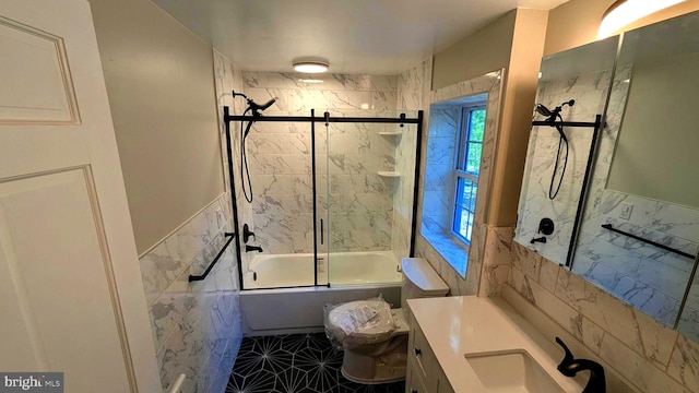 full bathroom with combined bath / shower with glass door, toilet, tile patterned floors, tile walls, and vanity