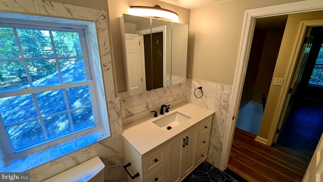 bathroom featuring hardwood / wood-style flooring, toilet, tile walls, and vanity