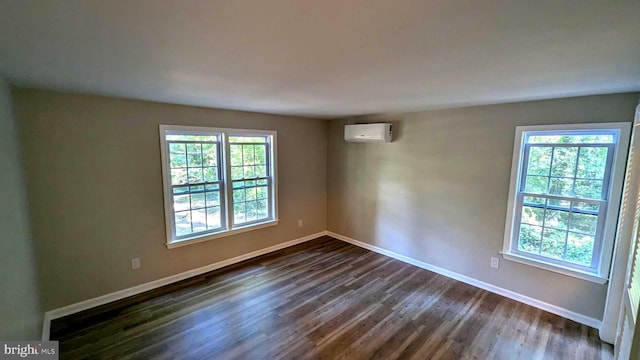 empty room with plenty of natural light, dark hardwood / wood-style floors, and a wall mounted AC