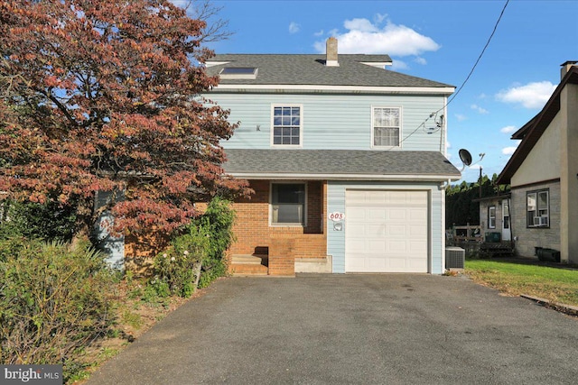 front of property with a garage and central AC unit