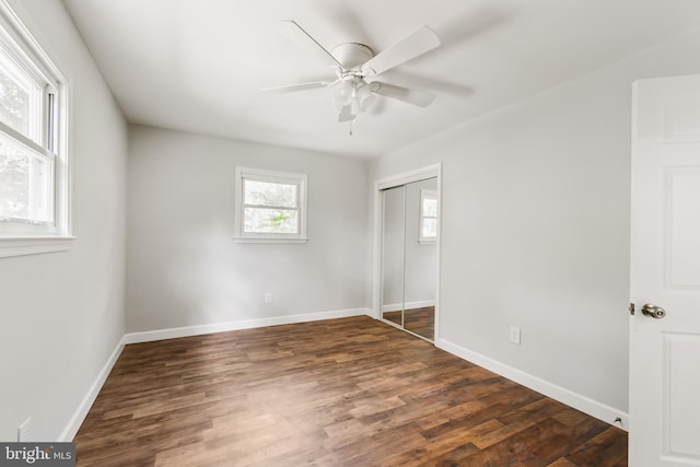 unfurnished bedroom featuring ceiling fan, dark wood-type flooring, and a closet