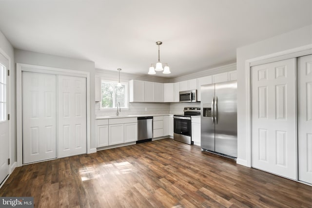 kitchen featuring a chandelier, dark hardwood / wood-style flooring, decorative light fixtures, stainless steel appliances, and white cabinets