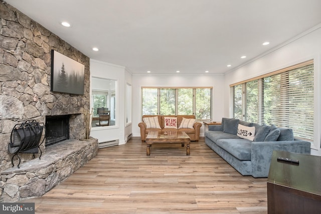 living room featuring a stone fireplace, ornamental molding, light hardwood / wood-style flooring, and a baseboard radiator