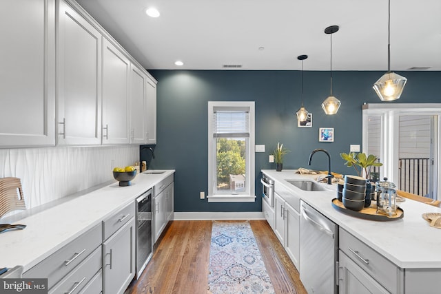 kitchen with sink, dishwasher, dark hardwood / wood-style flooring, decorative light fixtures, and wine cooler