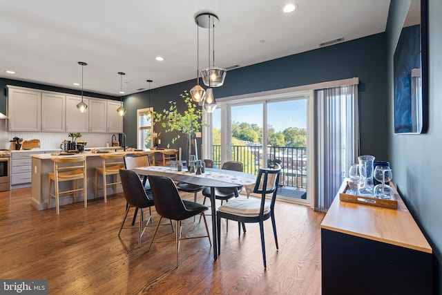 dining space featuring hardwood / wood-style flooring and sink