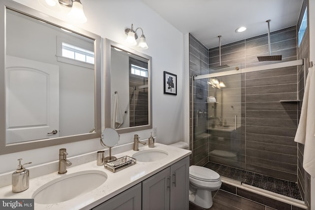 bathroom with vanity, toilet, and a shower with shower door