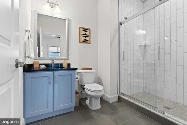 bathroom featuring vanity, an enclosed shower, toilet, and tile patterned floors