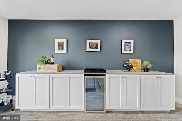 bar with white cabinetry and wine cooler