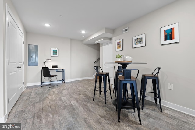 dining area with wood-type flooring and electric panel