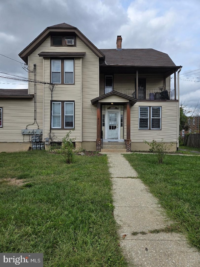 front of property with a balcony and a front yard