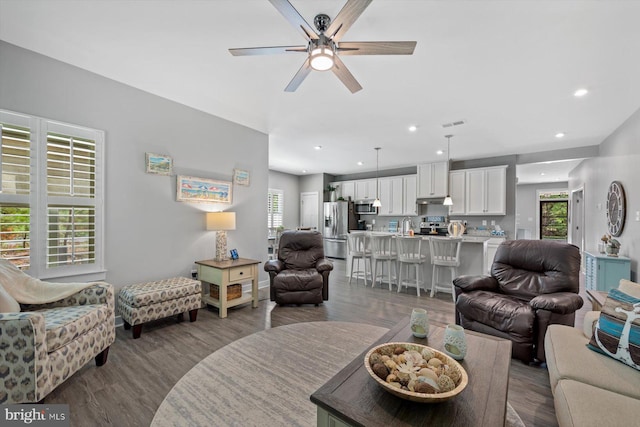 living area with recessed lighting, plenty of natural light, dark wood-style flooring, and ceiling fan