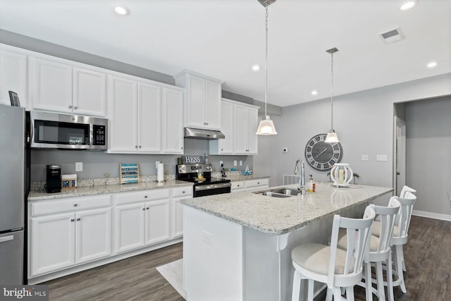 kitchen featuring pendant lighting, an island with sink, white cabinets, sink, and appliances with stainless steel finishes