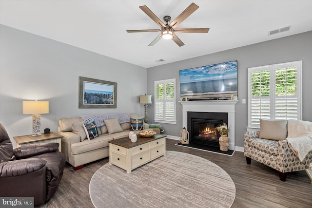 living room featuring ceiling fan, plenty of natural light, and dark hardwood / wood-style flooring