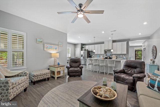 living room featuring ceiling fan and hardwood / wood-style flooring