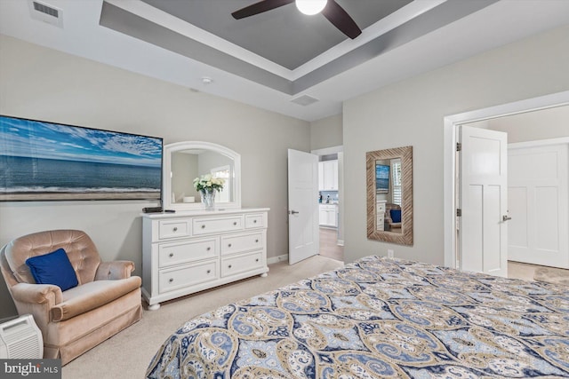 carpeted bedroom featuring a tray ceiling and ceiling fan