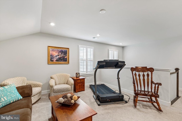 exercise room with vaulted ceiling and light colored carpet