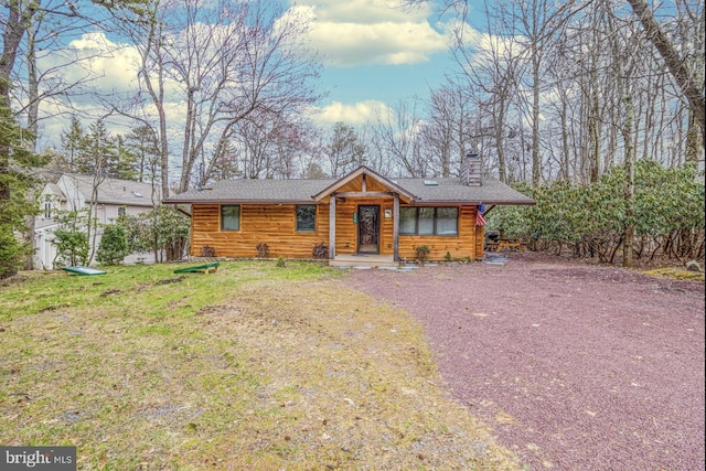 log cabin with a front lawn