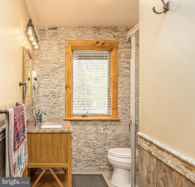 bathroom featuring tile walls, walk in shower, tile patterned floors, vanity, and toilet