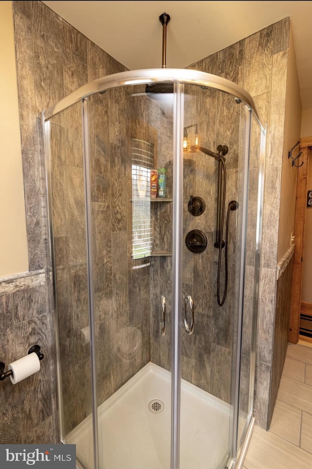 bathroom with tile walls, walk in shower, and tile patterned floors