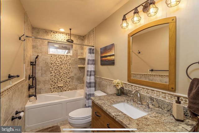 full bathroom with tile walls, shower / bath combo, vanity, and toilet