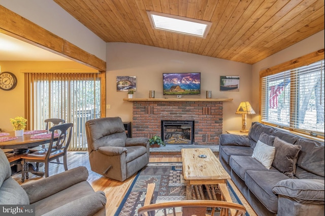 living room with wood ceiling, lofted ceiling with skylight, hardwood / wood-style floors, and a brick fireplace