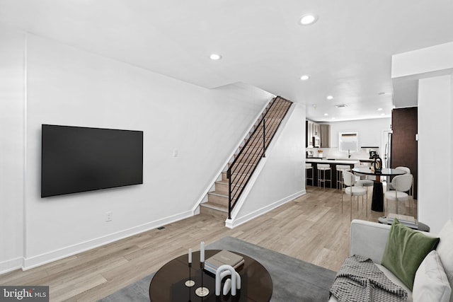 living room featuring light wood-type flooring and sink