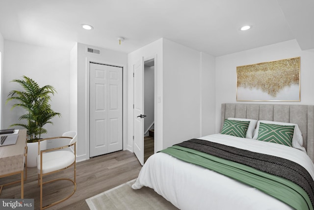 bedroom with a closet and hardwood / wood-style floors