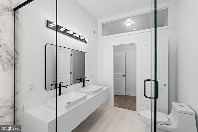 bathroom featuring walk in shower, vanity, toilet, and tile patterned floors