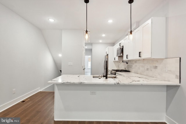 kitchen featuring pendant lighting, kitchen peninsula, light stone countertops, white cabinetry, and stainless steel appliances