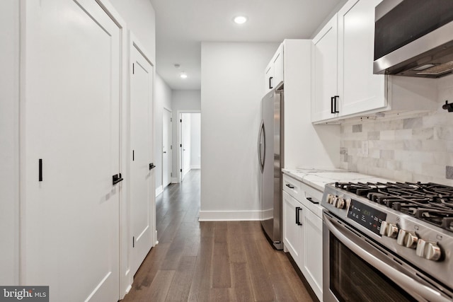 kitchen featuring light stone countertops, dark wood-type flooring, stainless steel appliances, tasteful backsplash, and white cabinets