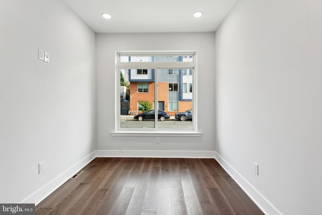 spare room featuring dark wood-type flooring