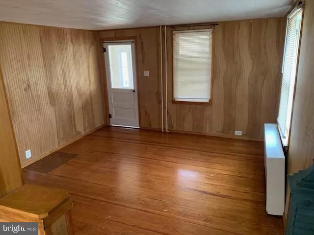 foyer entrance featuring light hardwood / wood-style floors and wood walls