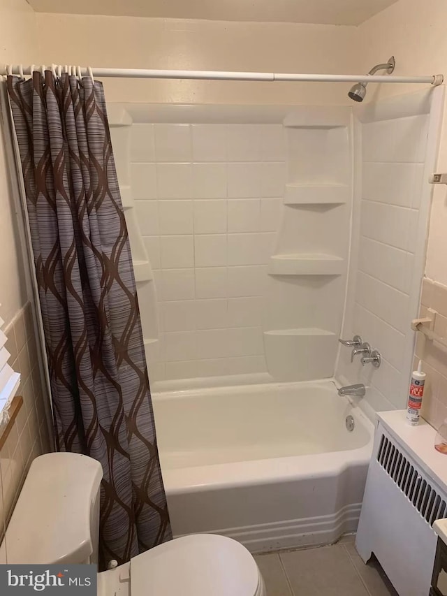 bathroom featuring shower / bathtub combination with curtain, toilet, and tile patterned floors