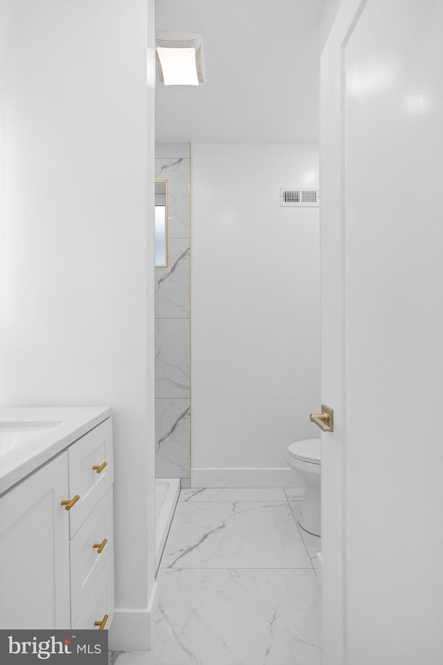 bathroom featuring vanity, toilet, and tiled shower