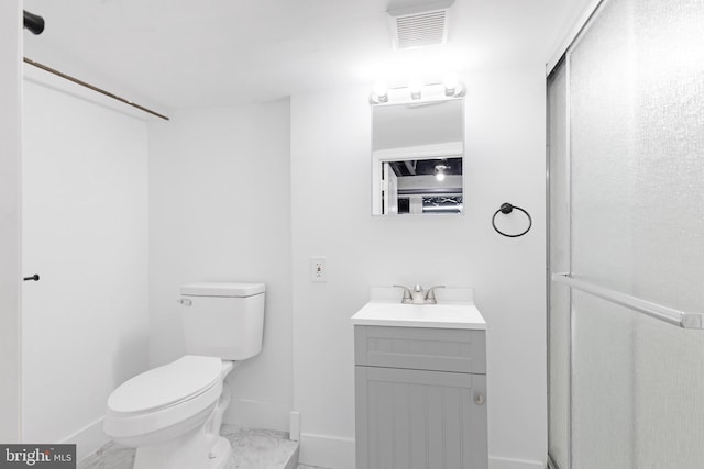 bathroom with vanity, a shower with door, and toilet