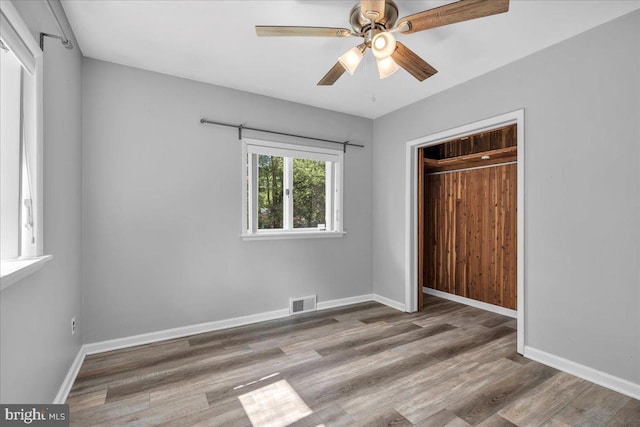 unfurnished bedroom featuring a closet, ceiling fan, and light wood-type flooring