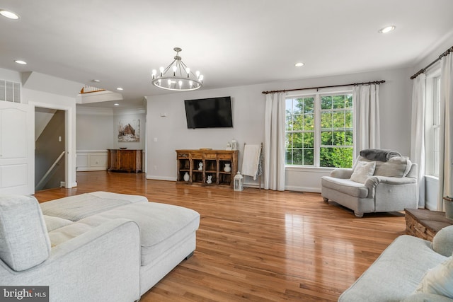 living room with hardwood / wood-style flooring and a notable chandelier