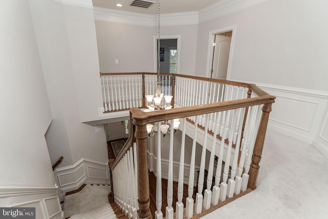 staircase with carpet flooring, an inviting chandelier, and ornamental molding