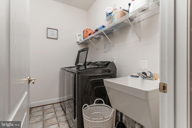 laundry room featuring washing machine and clothes dryer and sink