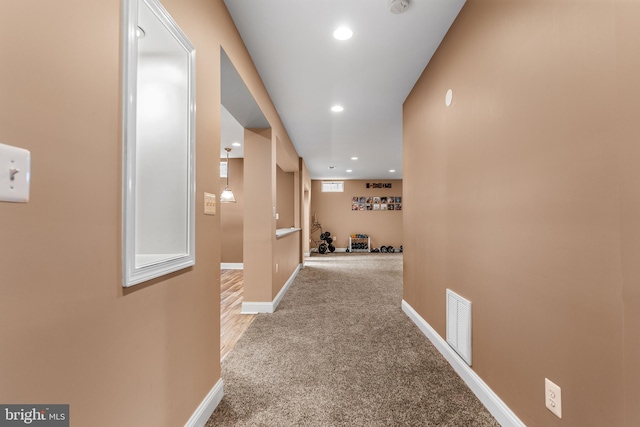 hallway featuring light colored carpet