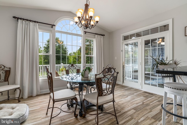 dining space featuring a notable chandelier, lofted ceiling, and light hardwood / wood-style floors