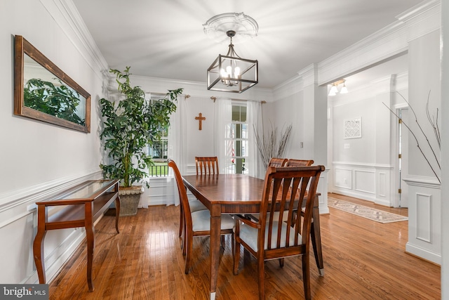 dining area featuring a notable chandelier, ornamental molding, and hardwood / wood-style floors