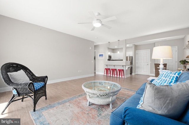 living room featuring light wood-type flooring and ceiling fan